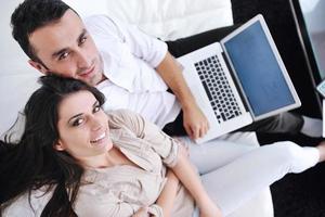 joyful couple relax and work on laptop computer at modern home photo