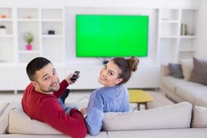 Young couple on the sofa watching television photo