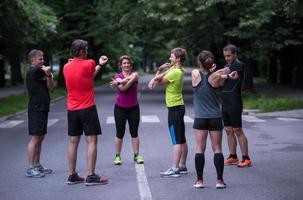 equipo de corredores calentando y estirando antes del entrenamiento matutino foto