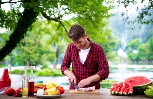 Man cutting meat for barbecue grill photo