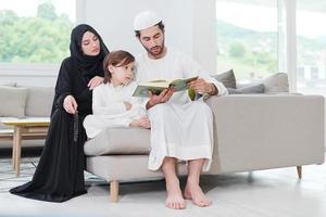 muslim family reading Quran and praying at home photo