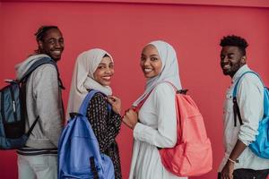 A group of African Muslim students with backpacks posing on a pink background. the concept of school education.
