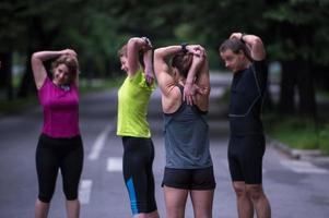 equipo de corredores calentando y estirando antes del entrenamiento matutino foto