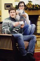 Young romantic couple relax on sofa in front of fireplace at home photo