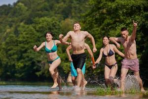 grupo de amigos felices divirtiéndose en el río foto