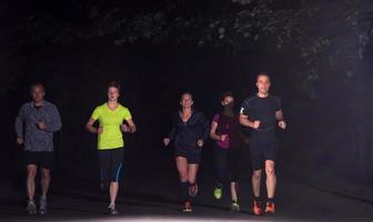 equipo de corredores en el entrenamiento nocturno foto