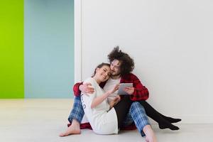 Young Couple using digital tablet on the floor photo