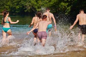 grupo de amigos felices divirtiéndose en el río foto