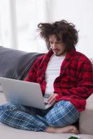 man freelancer in bathrobe working from home photo