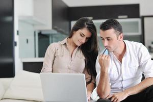 joyful couple relax and work on laptop computer at modern home photo