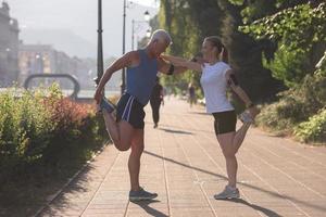 couple warming up and stretching before jogging photo