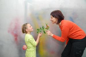 niña dando flores a la madre foto