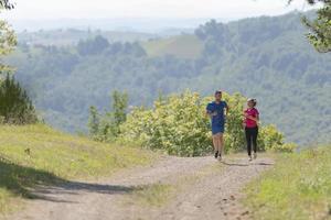 couple enjoying in a healthy lifestyle while jogging on a country road photo