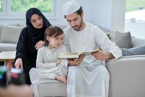 joven familia musulmana leyendo el corán durante el ramadán foto