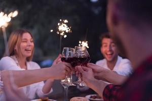 friends toasting red wine glass while having picnic french dinner party outdoor photo