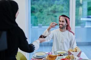 pareja musulmana compartiendo fechas para comenzar el iftar foto