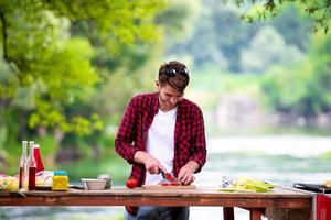 Man cutting vegetables for salad or barbecue grill photo