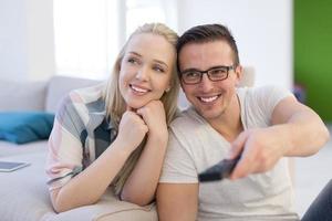 Young couple on the sofa watching television photo