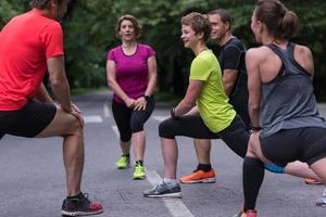 equipo de corredores calentando y estirando antes del entrenamiento matutino foto