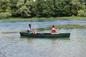 friends are canoeing in a wild river photo