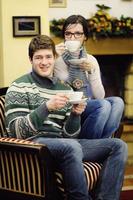 Young romantic couple sitting on sofa in front of fireplace at home photo