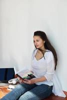 relaxed young woman at home working on laptop photo