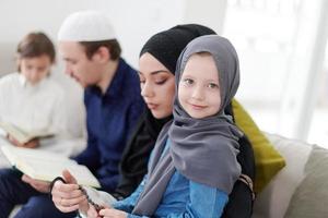 familia musulmana leyendo el corán y rezando en casa foto