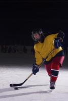 jugador adolescente de hockey sobre hielo en acción foto