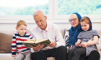 modern muslim grandparents with grandchildren reading Quran photo