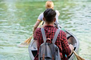 friends are canoeing in a wild river photo