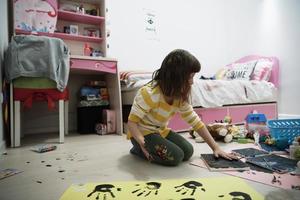 linda niña en casa pintando con las manos foto