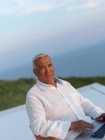 relaxed senior man on balcony photo