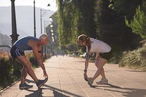 couple warming up and stretching before jogging photo