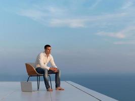 relaxed young man at home on balcony photo