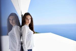 relaxed woman in front of luxury modern home photo