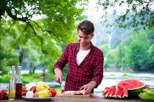 Man cutting meat for barbecue grill photo