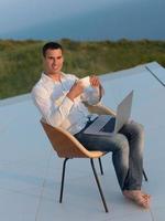 relaxed young man at home on balcony photo