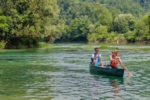 friends are canoeing in a wild river photo