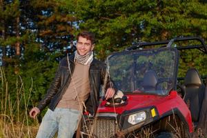 man enjoying beautiful sunny day smoking a cigarette while taking a break from driving a off road buggy car photo