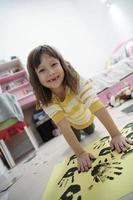 cute little girl at home painting with hands photo