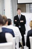 Young  business man giving a presentation on conference photo