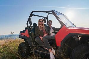 pareja disfrutando de un hermoso día soleado mientras conduce un buggy todoterreno foto