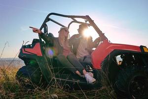 pareja disfrutando de un hermoso día soleado mientras conduce un buggy todoterreno foto