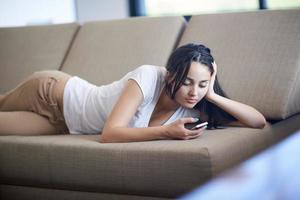 young woman using cellphone at home photo