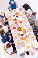 vista superior de la familia musulmana multiétnica moderna esperando el comienzo de la cena iftar foto