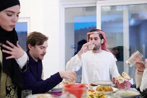 familia musulmana cenando iftar bebiendo agua para romper la fiesta foto