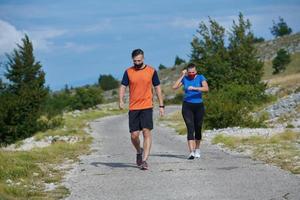 couple of running in nature wearing mask having a break photo