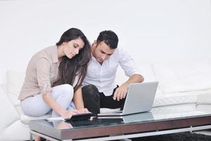 joyful couple relax and work on laptop computer at modern home photo
