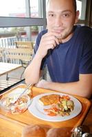 hombre comiendo comida saludable en un restaurante foto