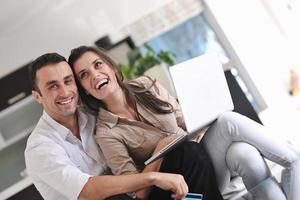 joyful couple relax and work on laptop computer at modern home photo